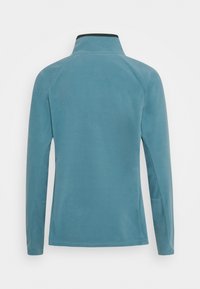 Kurtka polarowa w kolorze morskim z wysokim kołnierzem, długimi rękawami i gładką fakturą. Posiada rękawy raglanowe i brak widocznych elementów metalowych.