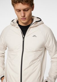 J.LINDEBERG Sports SHAWN HYBRID HOODED JACKET - Giacca outdoor - moonbeam
