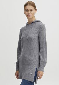 Grå ribbad stickad hoodie med snörning, sidofickor och en liten knappdetalj. Långa ärmar och en avslappnad passform ökar komforten.