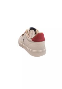 Sneaker beige con un accento rosso sul tallone, tomaia testurizzata e suola in gomma. Presenta un logo sul lato e un dettaglio cucito sul tallone.