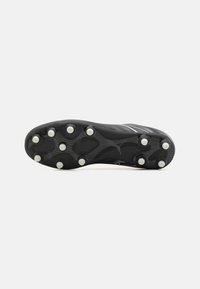 Suela de bota de fútbol negra con una superficie texturizada, nueve tacos circulares en blanco y un logo cerca de la zona del talón.
