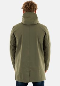 Manteau imperméable vert olive avec un col haut, texture lisse, manches longues et un dos fendu pour la ventilation. Design minimaliste.