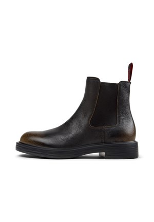 Stylish black Chelsea boot featuring textured leather, a rubber sole, and elastic side panels for easy wear.