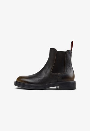Stylish black Chelsea boot featuring textured leather, a rubber sole, and elastic side panels for easy wear.