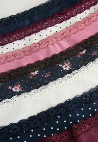 Sept bandes de tissu horizontales en bleu marine, bordeaux, rose, marron et blanc avec des motifs floraux et à pois, chacune bordée d'une dentelle assortie.
