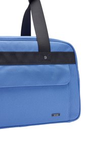 Niebieska torba podróżna z gładką teksturą, czarnymi nylonowymi paskami, przednią kieszenią oraz małym metalowym logo po boku.