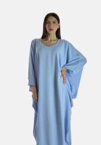 Kaftan oversize bleu clair avec un col en V, des manches larges et un tissu doux et texturé, tombant lâchement jusqu'aux chevilles.