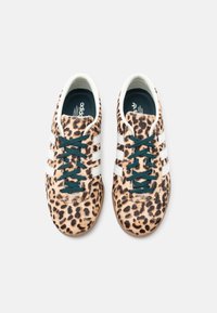 Αθλητικά παπούτσια με λεοπάρ σχέδιο, υφασμάτινο πάνω μέρος, λευκό σχέδιο με τρεις ρίγες, σκουροπράσινα κορδόνια και επενδυμένη γλώσσα. Ελαφριά, με λαστιχένια σόλα.