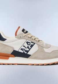 Beiger und weißer Sneaker mit braunen und schwarzen Akzenten, strukturierter Sohle und "NAP" Logo-Banner an der Seitenfläche.