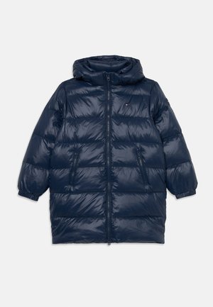 Navy blue puffer jacket with a hood, zip closure, two side pockets, quilted texture, and elastic cuffs. Features discrete logo on chest.