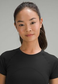 Zwart sportshirt met korte mouwen, van textuurstof en met een ronde hals. Het ontwerp heeft platte naden en een aansluitende pasvorm.