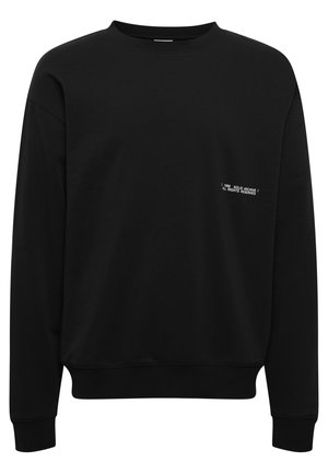 Musthave musta dressipluus, millel on ümar kaelus, pikad varrukad ja soonikkant. Ees on valge tekst, mis ütleb "1999 SOLID ARCHIVE / KÕIK ÕIGUSED KAITSTUD."