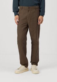 Brown trousers made of soft cotton fabric, featuring a straight leg design, front button closure, and side pockets.