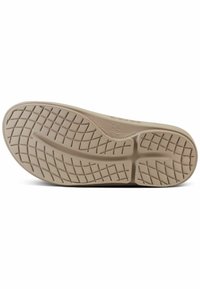 Shoe sole with a beige rubber material featuring a textured, grid pattern for grip and flexibility, including brand markings on the surface.