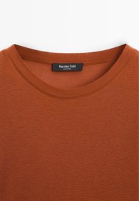 Rust-colored ribbed t-shirt with a round neckline and a label reading "Massimo Dutti." Smooth texture and fitted design.