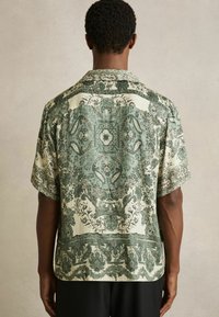 Korte mouwen shirt met een groen en crème paisleypatroon, met een losse pasvorm, glanzende textuur en een rechte zoom.