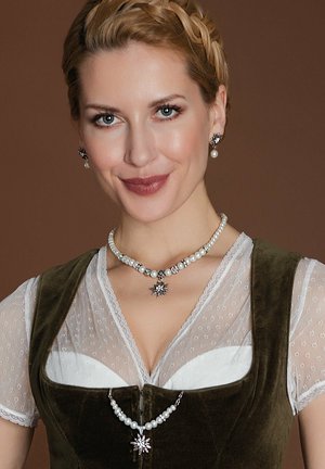 Green velvet dress with lace accents, layered over a white blouse. Pearl and silver jewelry includes a star pendant and matching earrings.