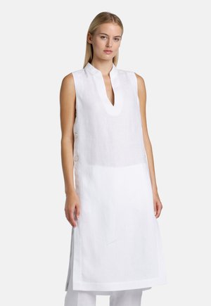 Witte linnen tuniek met een V-hals en zonder mouwen, met zijsplitten en knopen aan één kant voor extra detail.