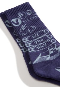 Lila Socken aus geripptem Strickstoff mit hellblauen Grafiken eines Hasen und Text, die ein gleichmäßiges Muster aufweisen.