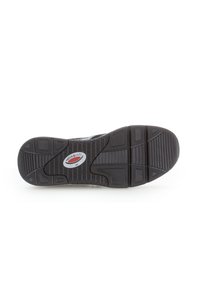 Zwarte rubberen schoenzool met gestructureerde grippatronen, voorzien van een cirkelvormig logo in het midden. Ontwikkeld voor grip en stabiliteit.