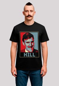 Black t-shirt featuring a stylized graphic of a man's face, with red and blue color blocks and the word "HILL" in blue at the bottom.
