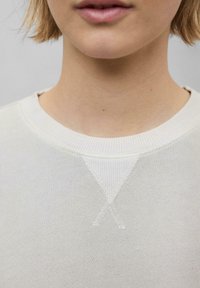 Sweatshirt à col ras du cou de couleur gris clair avec un col en rib et un détail en V cousu sur la poitrine, fabriqué à partir d'un matériau en coton doux.