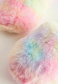 Luddiga tofflor i pastellfärger, med en fluffig textur och en regnbågsgradient, främst i rosa, blå och gröna nyanser.
