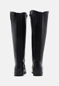 Bottes noires en cuir montantes jusqu'aux genoux avec une finition lisse, dotées d'une fermeture éclair et de panneaux latéraux élastiques pour plus de flexibilité. Talon bas empilé.