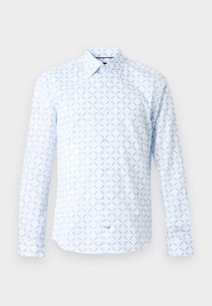 Camicia bianca a maniche lunghe con bottoni, decorata con un motivo geometrico a stella azzurro chiaro e colletto classico, su sfondo neutro.