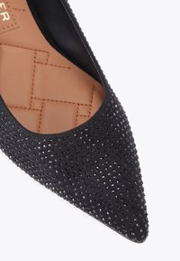 Ballerine nere a punta con un esterno texture e strass neri. L'interno è in morbida pelle color tan con un motivo intrecciato.