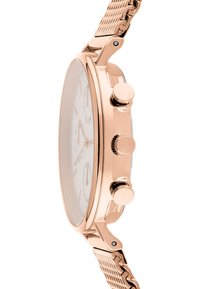 Roséguld klocka med rund boett, vit urtavla och nätarmband. Har två knappar och en krona på höger sida för tidsjusteringar.