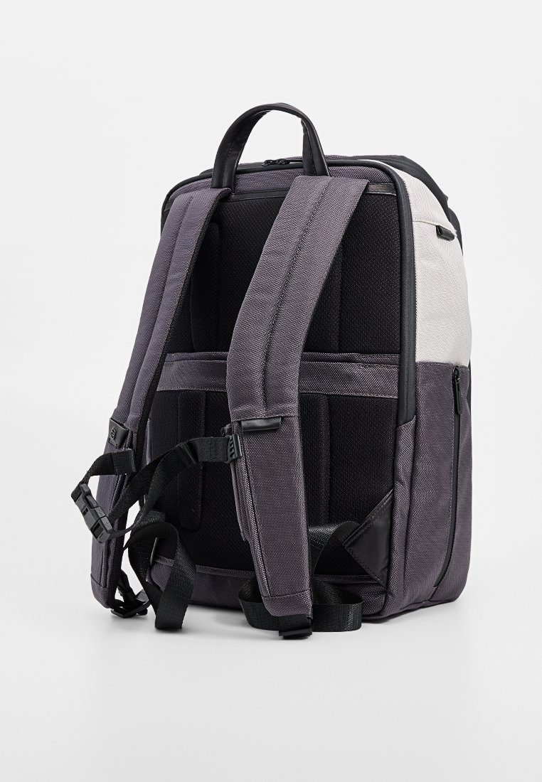 Zaino con tessuto viola e nero, spallacci imbottiti, una maniglia superiore e compartimenti in rete. Presenta una sezione contrastante grigio chiaro.