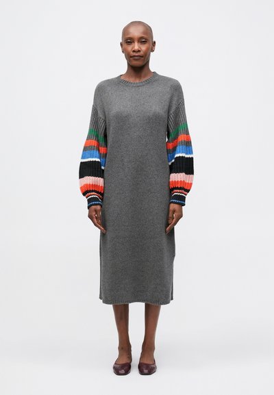 Robe en laine grise avec de longues manches ballons colorées aux motifs rouges, bleus, verts et noirs. Encolure ras du cou et longueur genou.