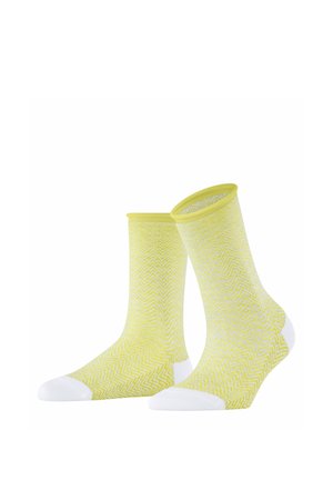 Gelbe Socken mit einem weißen Zickzackmuster, die weiße Akzente an Spitze und Ferse aufweisen. Hergestellt aus weichem, dehnbarem Material mit einem gerippten Bündchen.