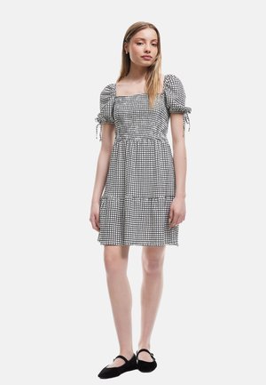 Schwarz-weiß kariertes Kleid mit quadratischem Ausschnitt, Puffärmel und gestuftem Rockdesign. Weicher Stoff mit leichter Textur.