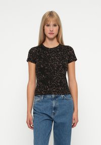 Czarny t-shirt z nadrukiem panterki, krótkie rękawy, dopasowany krój, miękka tekstura, okrągły dekolt, połączony z niebieskimi dżinsami z wysokim stanem.