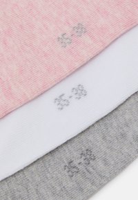 Tres pares de calcetines: rosa, blanco y gris. Cada uno presenta un patrón de punto texturizado con pequeños logotipos grises en la punta.
