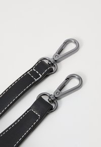 Correa de cuero negra con costuras blancas, equipada con ganchos y herrajes metálicos en color gris para su sujeción. Diseño plano con textura suave.
