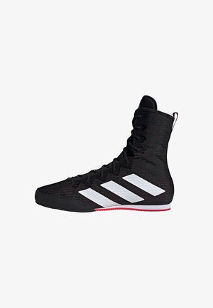 Black high-top athletic shoe made of textured synthetic material, featuring white stripes and a red accent on the sole.