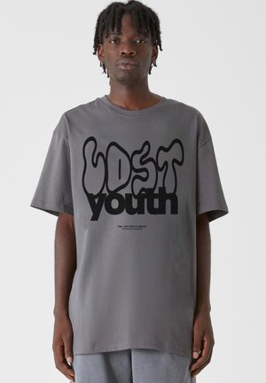 Šedé oversized tričko z bavlny s tekoucím černým designem textu "LOST youth". Krátké rukávy a klasický kulatý výstřih.