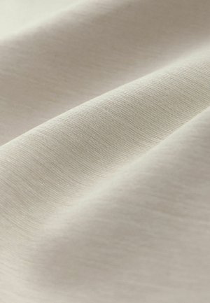 Heledalt beež kangas tekstuurse pinnaga, millel on õrnad voltid ja peen läige. Kude näib olevat tihe ja ühtlane kogu pinnal.