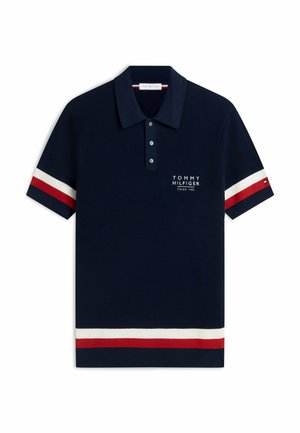 Granatowa koszulka polo z czerwono-białymi paskami na rękawach i obrzeżu, listwa z trzema guzikami oraz białe logo Tommy Hilfiger na piersi.