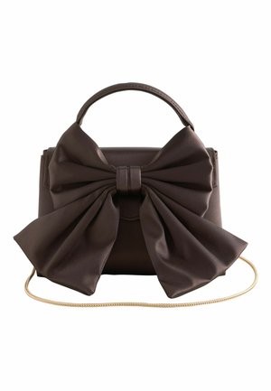 Dunkelbraune Lederhandtasche mit großem, strukturiertem Schleifendetail vorne, obenliegendem Griff und dünnem goldfarbenem Kettenriemen auf weißem Hintergrund.