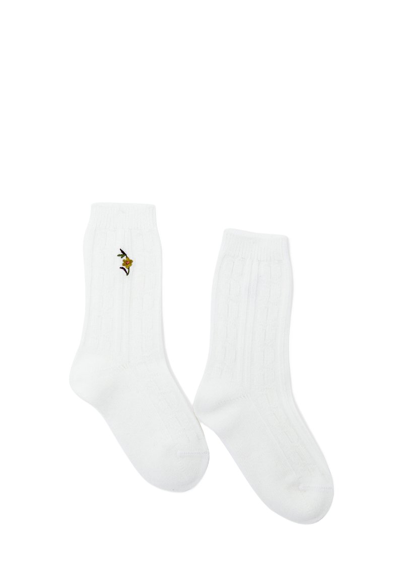 Calzini bianchi in cotone alla caviglia con texture a coste, caratterizzati da un piccolo design di un uccellino ricamato a colori sul lato.