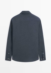 Donkergrijs shirt met lange mouwen en knoopmanchetten, gezien vanaf de achterkant op een witte achtergrond.