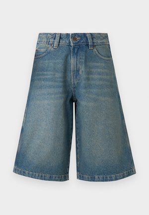 Modré rifľové šortky po kolená s predným gombíkom, zipsom, pútkami na opasok a vreckami na jednoduchom svetlom pozadí.