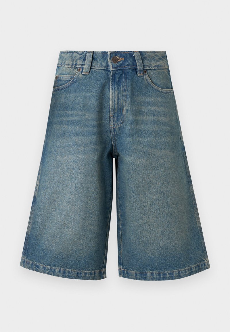 Μπλε τζιν σορτς μέχρι το γόνατο με κουμπί μπροστά, φερμουάρ, θηλιές για ζώνη και τσέπες σε απλό ανοιχτό φόντο.