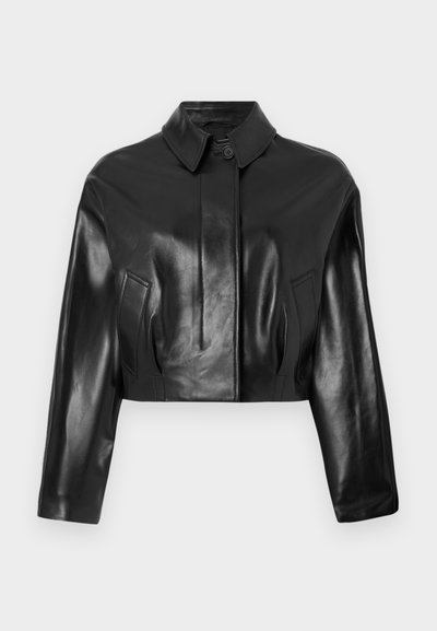Chaqueta de cuero negra, corta, con cuello puntiagudo, cierre frontal de botones y bolsillos laterales. Presenta una textura suave y un diseño entallado.