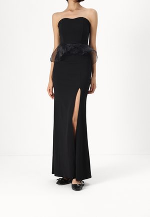 Schwarzes trägerloses Kleid mit herzförmigem Ausschnitt, eng anliegendem Oberteil, transparenter Peplum-Taille, Schlitz bis zum Oberschenkel und bodenlanger Silhouette.