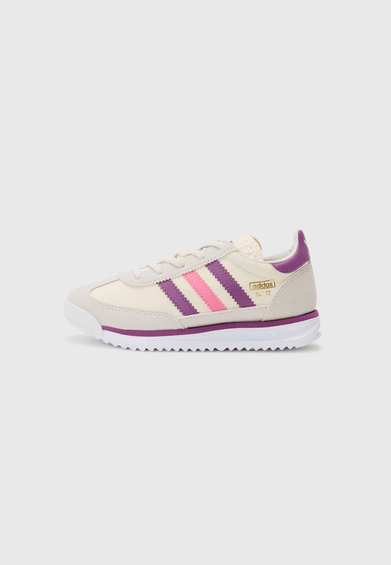 Beige sneakers med rosa og lilla striper, teksturert overdel, gummisåle og logo aksenter på siden og baksiden. Klassisk atletisk design.